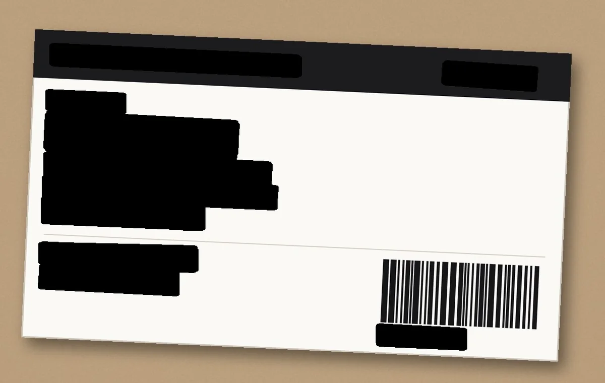 The same label after ConsentGuard ran: the name, address, phone number, courier and order code are covered by solid black blocks.